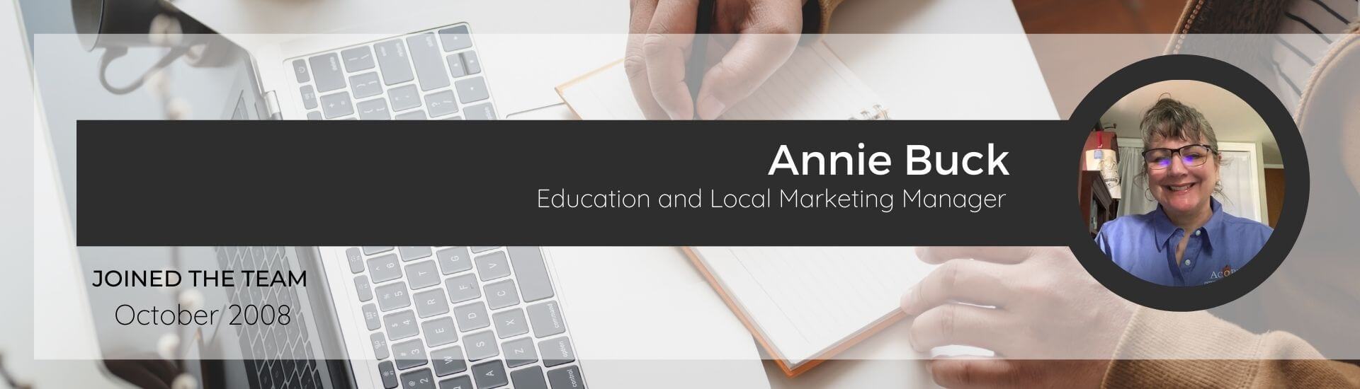 Annie Buck, Education Manager for Acorn Marketing, on a background of a person working on a laptop and notebook.