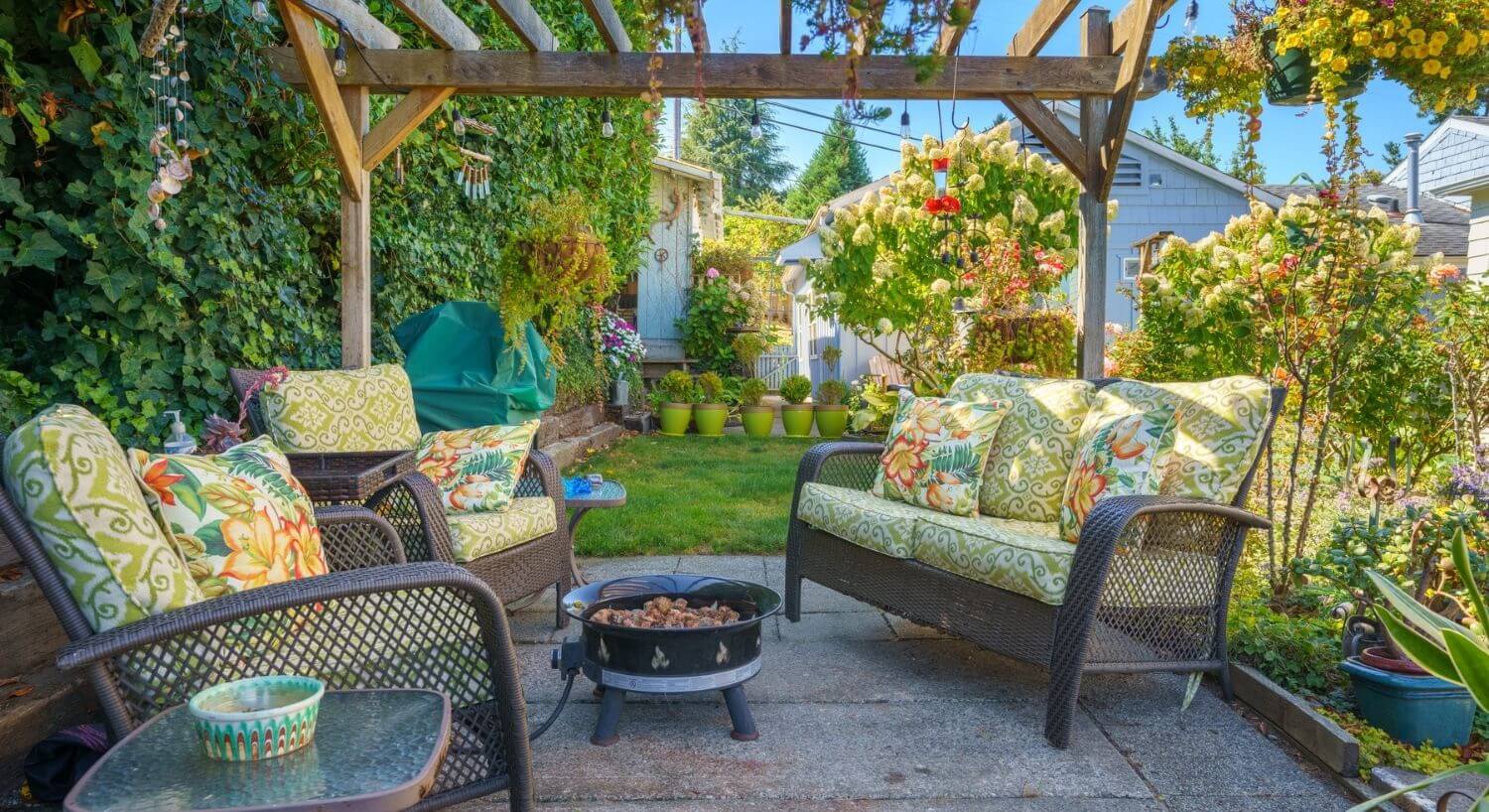	Pretty exterior seating area with wicker furniture and pergola.