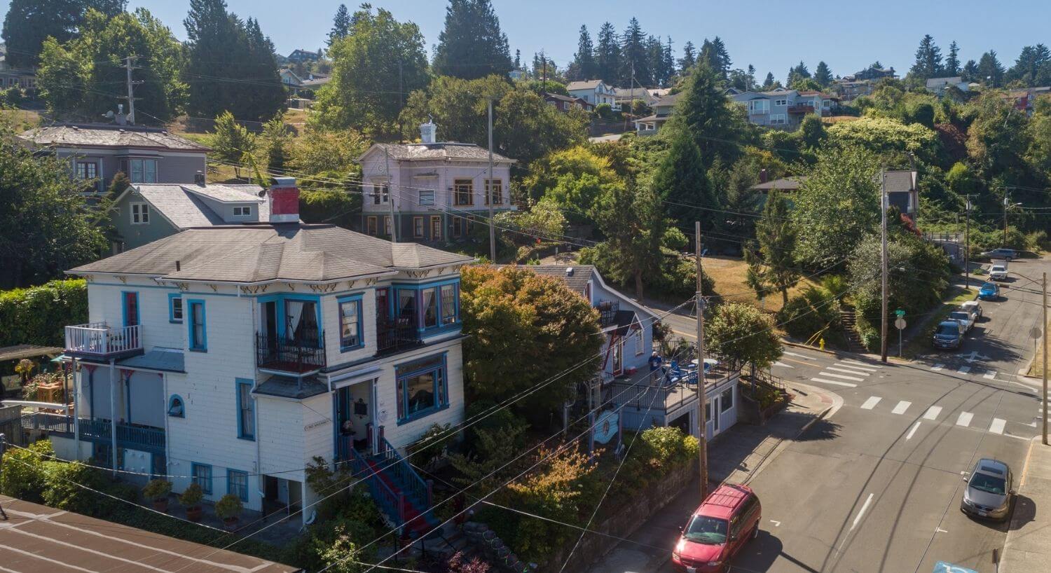 Arial view of large Italianate-style home - white with blue trim
