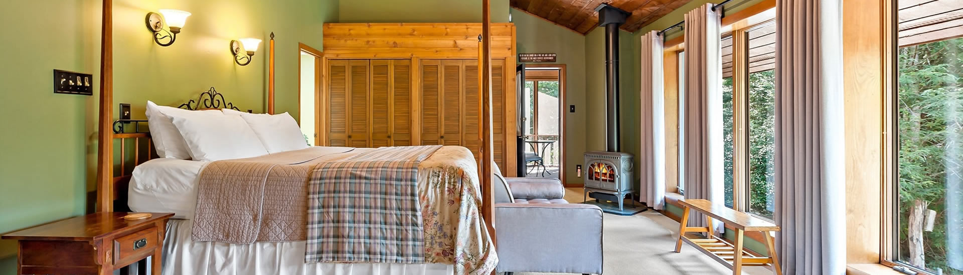 Bedroom with 4-post bed, large wooden armoire and fan on vaulted ceiling