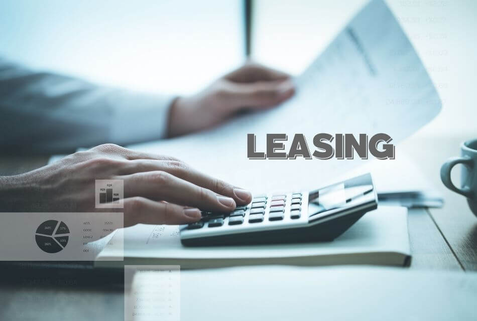 A person tapping on a calculator while holding papaers int he other hand with the word LEASING overlaid on the image