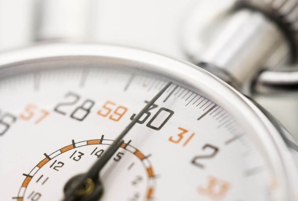 Close-up of a silver stopwatch with the hand pointing to 30