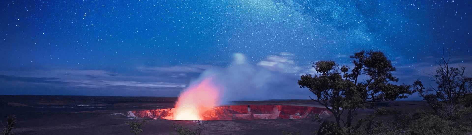 Volcano flaring from the ground against an expanse of the Milky Way